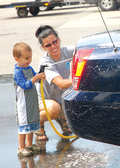Caleb and Sandi Binette washing cars